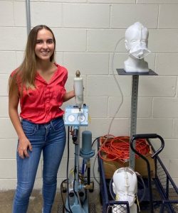 Student Gracia Dardano posing with Airborne Nanoparticle FIltration Equipment